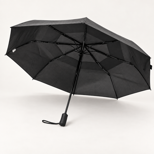 Black Flex Plus umbrella open, showing the vented canopy, ribs, handle, and wrist strap